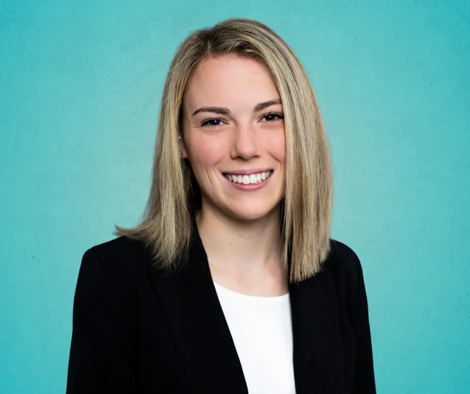 Annie Gerding, DVM smiling in a blazer in front of a gradient teal background