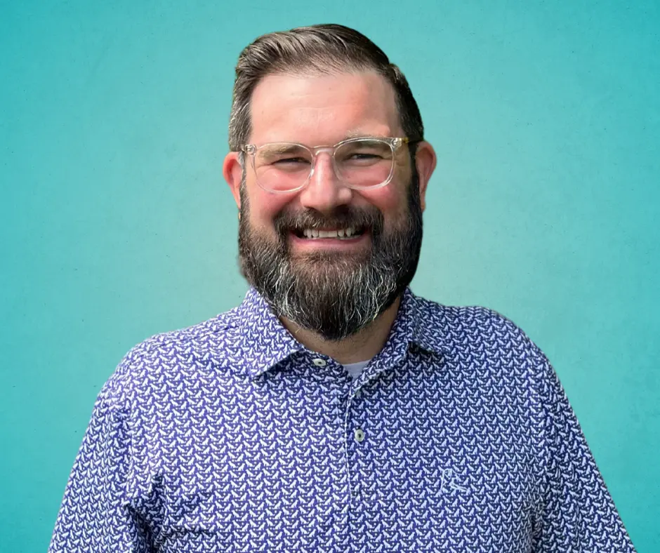 Dustin Beauchamp, DVM smiling on a teal gradient background
