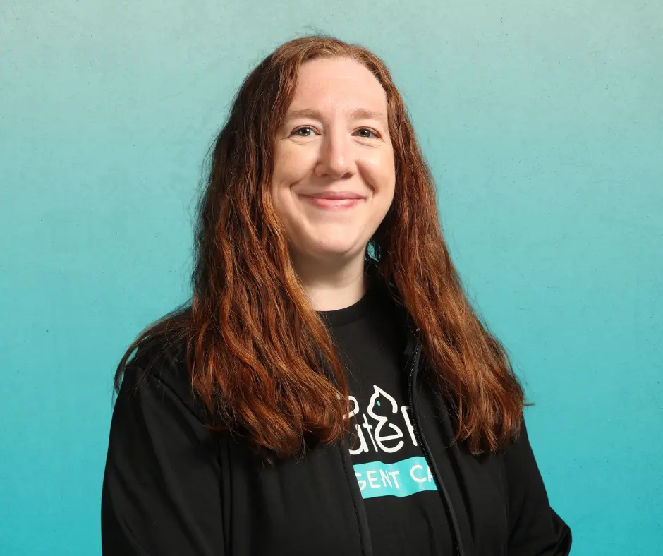 Katelyn Boles, FFCE ActutePet Cincinnati (White Oak) Practice Manager smiling in an AcutePet shirt on a teal background